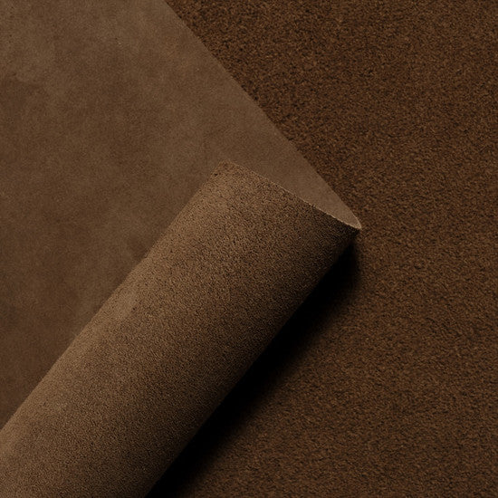 Rolled suede leather hide in deep tobacco brown, highlighting the rich texture and soft velvety nap of premium Italian suede from Opera Conceria