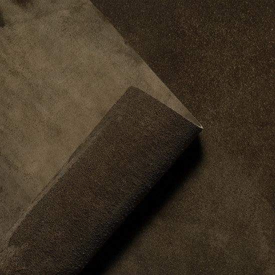Rolled suede leather hide in earthy olive green, highlighting the soft velvety nap and natural texture of premium Italian suede from Opera Conceria.