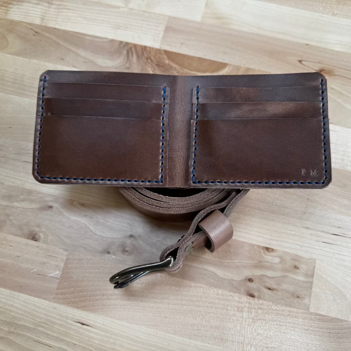 The interior of the handmade Horween Natural Chromexcel leather wallet showing blue stitching detail.
