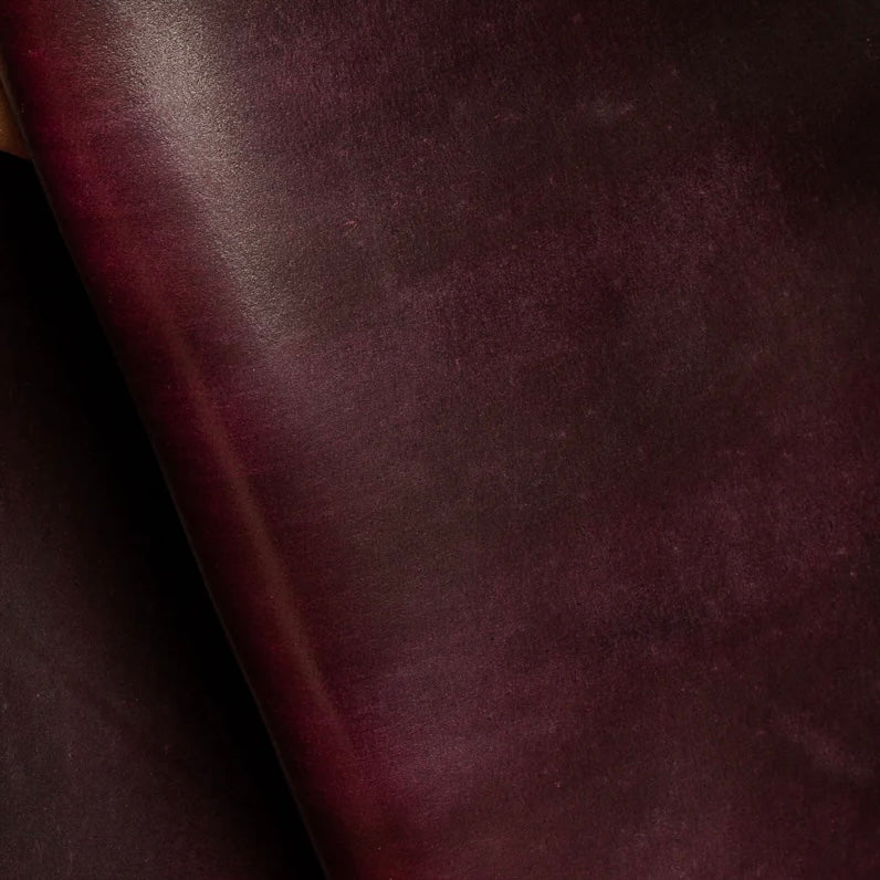 Detailed macro texture shot highlighting the deep burgundy tones and smooth, dense grain of premium Horween Shell Cordovan leather.
