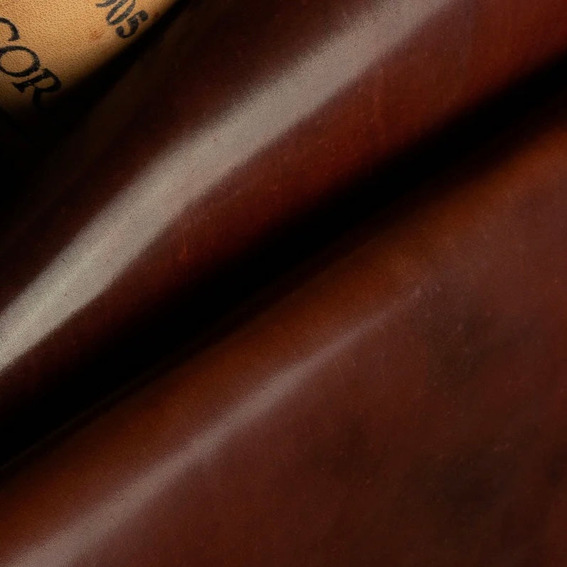 Detailed macro texture shot highlighting the rich cognac tones and smooth, dense grain of premium Horween Shell Cordovan leather.