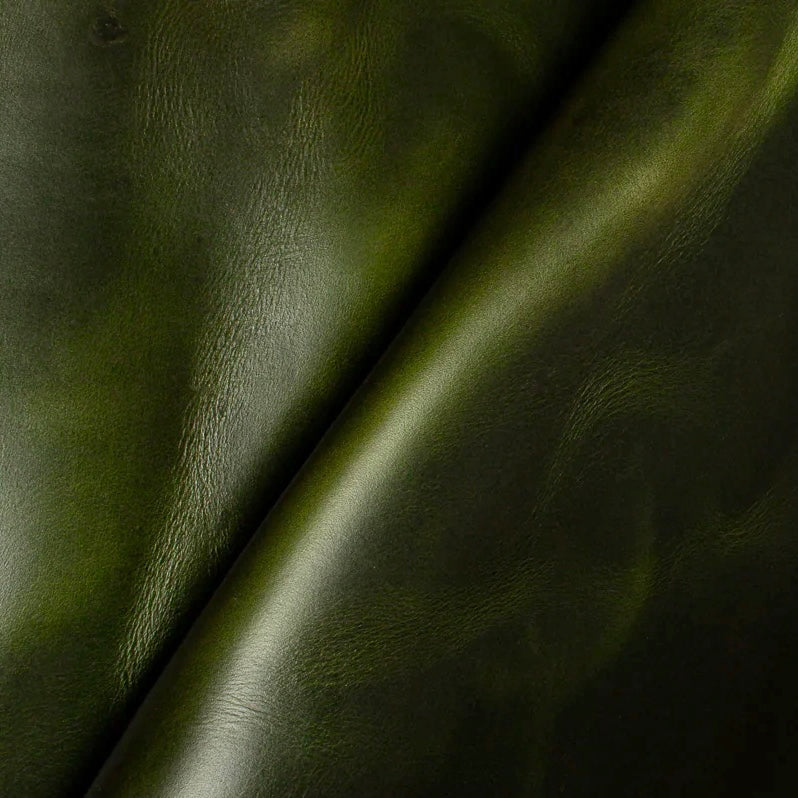 Detailed macro texture shot highlighting the vibrant forest green tones and characteristic pull-up effect of premium Horween Chromexcel leather.