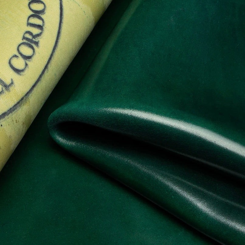 Detailed macro texture shot highlighting the rich forest green tones and smooth, dense grain of premium Horween Shell Cordovan leather.