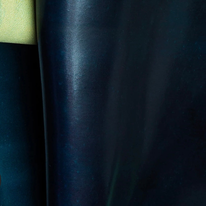 Detailed macro texture shot highlighting the deep navy blue tones, dense grainless surface, and premium quality of genuine Horween Shell Cordovan leather.