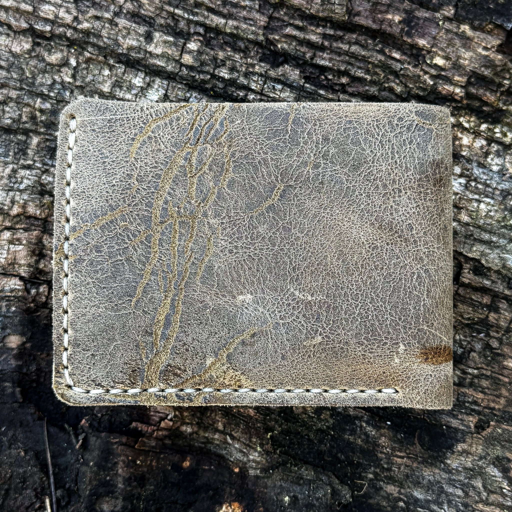 Exterior view of the handcrafted No. 1652 JAGTER field bifold wallet in Desert color Wild African Kudu leather, showing prominent natural striations and unique hide scarring.