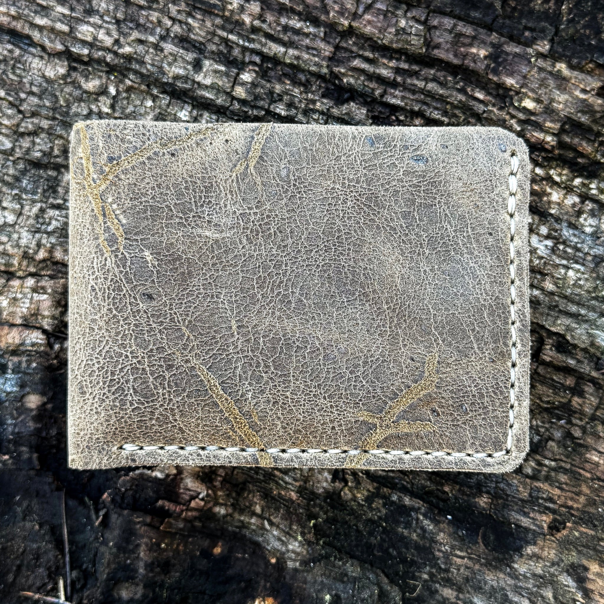 Handcrafted No. 1652 JAGTER field bifold wallet in rare Wild African Kudu leather, showcasing unique, rugged natural grain and scarring.