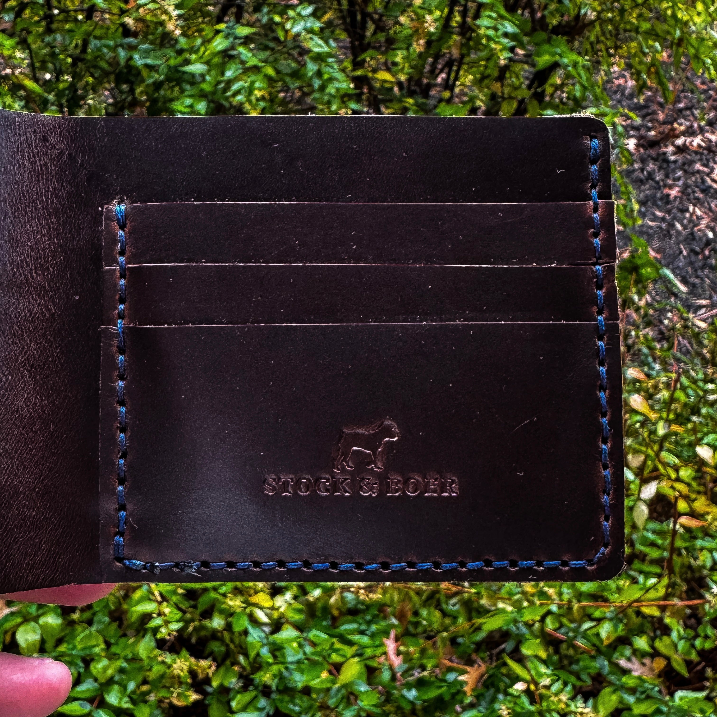 Close-up of the interior card slots and embossed Stock & Boer logo on the No. 2 Frontiersman Leather Bifold Wallet. Handcrafted from Brown Chromexcel leather with heavy-duty blue stitching.